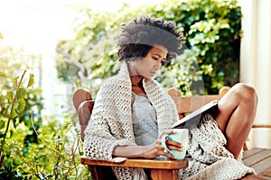 Black woman, reading and coffee for outside in nature, book and backyard or garden for relax. Patio, bench and tea cup