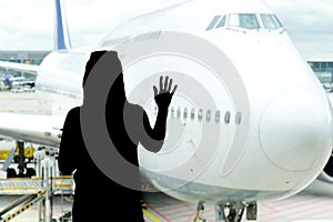 Black woman silhouette looking to aircraft in the airport hall- missed or cancelled flight concept.