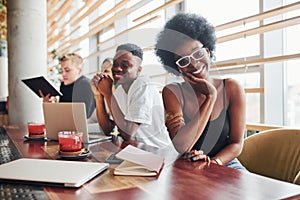 Black woman sitting in front of group of multi ethnic people with alternative girl with green hair is working together