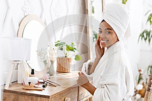 Black Woman Sitting At Toilet Table And Touching Her Perfect Skin