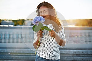 Black woman smelling a pretty flower