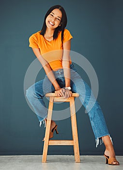 Black woman, smile and portrait of a young model sitting on a stool in a studio. Casual fashion, happiness and youth of