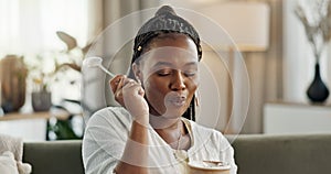 Black woman on sofa, eating ice cream and relax in living room with smile, summer pleasure and enjoy. Happiness, fun or