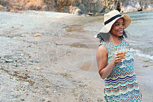 Black woman standing holding a glass of wine in her hands