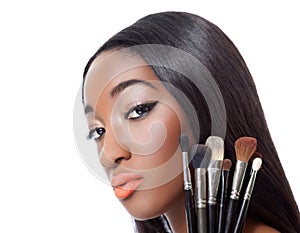 Black woman with straight hair holding makeup brushes photo