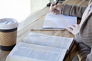 Black woman studies her bible and takes notes