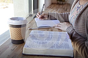 Black woman studies her bible and takes notes