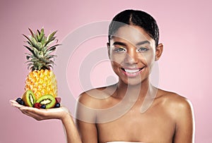Black woman, studio portrait and fruit in hand for beauty with tropical food, makeup and diet with vitamins. African