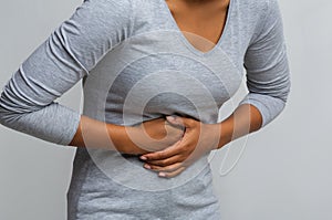 Black woman suffering from gastritis, touching her tummy