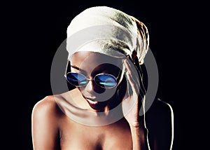 Black woman, sunglasses and headscarf with fashion for style on a dark studio background. Face of young African female