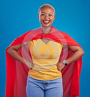 Black woman, superhero cape and portrait in studio, blue background and fashion. Happy female model, superwoman and