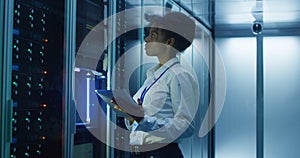 Black woman with tablet working in server room