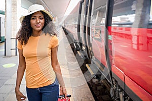 Black woman taking the train in station platform
