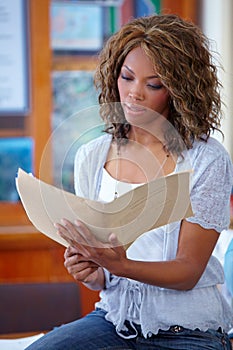 Black woman, teacher and reading documents in classroom for education or learning syllabus. African female person