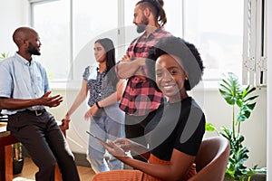 Black woman in tech, chatting to coding colleagues informal meeting in office