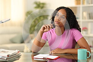 Black woman thinking with agenda at home