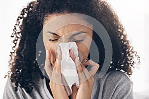 Black woman, tissue and sneeze of a sick young person blowing nose with toilet paper for safety. Flu, fever and cold of