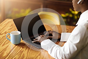 Black woman typing on laptop with blank screen, cropped, mockup