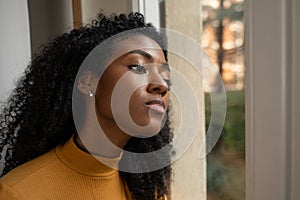 A black woman very curious watching outside the window