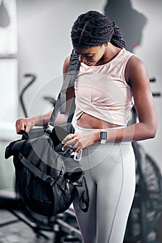Black woman, water bottle or fitness bag in gym workout break, cardio training or heart health exercise for strong body