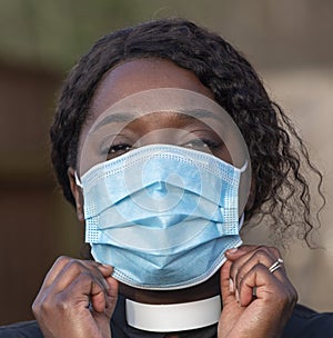 Black woman wearing Covid mask and dog collar