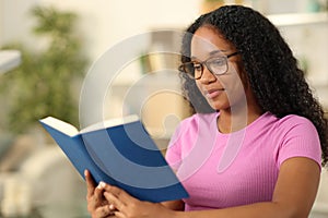 Black woman wearing eyeglass reading book