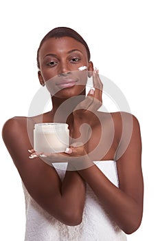 Black woman wrapped in towel moisturizing face photo