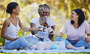 Black women, picnic and beer toast in park, nature environment or sustainability garden with food, popcorn or cotton