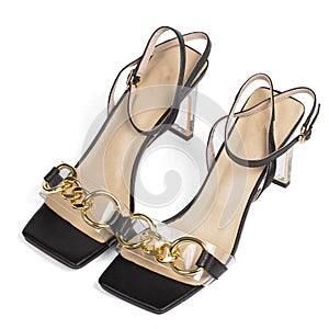 Black women's sandals on a medium transparent wide heel with a beige insole and a blunt toe on a white background