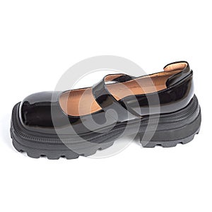 Black women's shiny glossy leather sandals on thick rubber sole on a white background