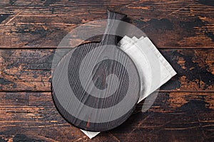 Black wooden Cutting board over towel on kitchen table. Wooden background. Top view. Copy space