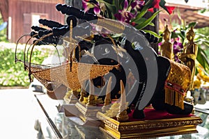 Black wooden elephants carry net basket