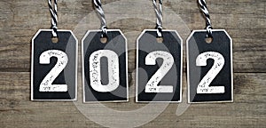 Black wooden hang tags with 2022 on weathered wood background