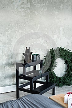 a black wooden ladder with three steps next to the bed as a shelf