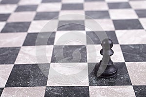 Black wooden pawn on chessboard