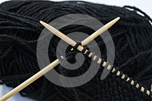 Black wool with bamboo knitting needles