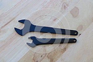 Black wrenches on wooden background