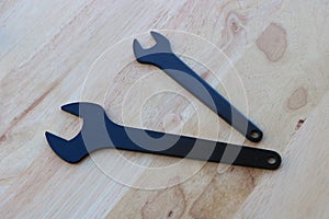 Black wrenches on wooden background