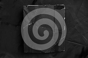 Black wrinkled paper with frayed folds on black wrinkled synthetic material photo