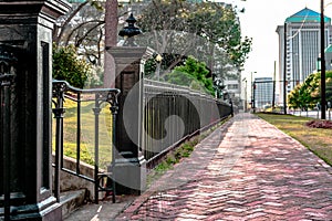 Black wrought iron fence next to sidewalk