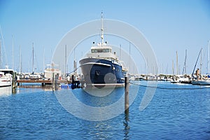 A black yacht in the port is waiting. The sea is calm.