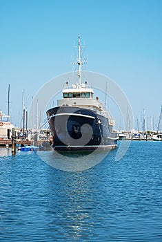 A black yacht in the port is waiting. The sea is calm.