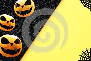 Black and yellow background with three halloween pumpkins and a spider web in the corners.