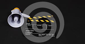 Black&yellow Clapperboard or movie clapper board and Megaphone in yellow color isolated on black background