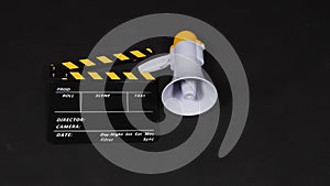 Black&yellow Clapperboard or movie clapper board and Megaphone in yellow color isolated on black background