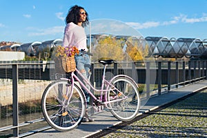 Black young woman riding a vintage bicycle