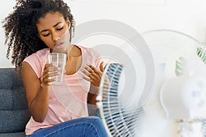 Black young woman suffering a heat wave at home