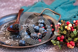 Blackberries and blueberries on a metal platter.