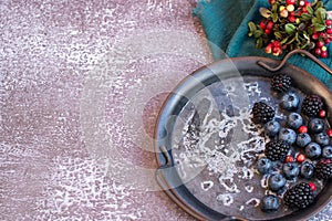 Blackberries and blueberries on a metal platter.