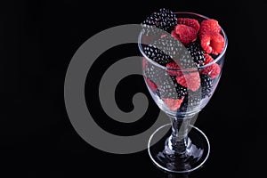 Blackberries and raspberries in a stemmed glass